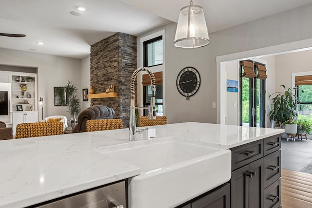 4203 Curtis Meadow Dr, Champaign, IL 61822 - kitchen featuring open floor plan, light stone counters, hanging light fixtures, a fireplace, and dishwashing machine