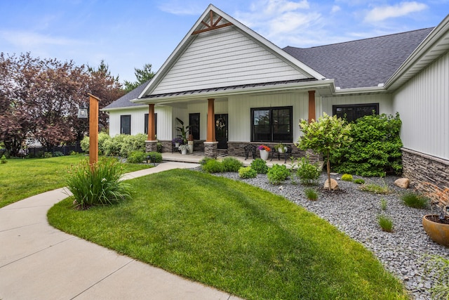 4203 Curtis Meadow Dr, Champaign, IL 61822 - view of front facade featuring covered porch, a front lawn, a standing seam roof, stone siding, and a shingled roof