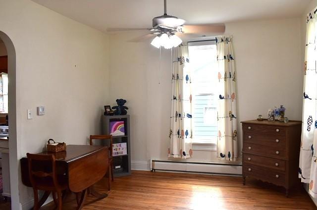 1207 4th Ave, Sterling, IL 61081 - sitting room featuring arched walkways, a baseboard radiator, ceiling fan, and wood finished floors