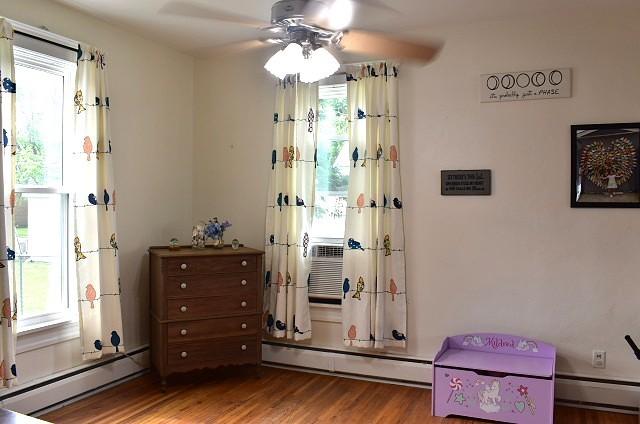1207 4th Ave, Sterling, IL 61081 - sitting room with a baseboard radiator, healthy amount of natural light, and wood finished floors