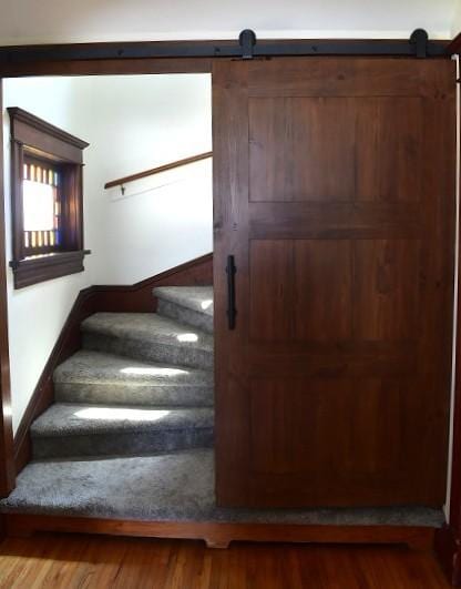 1207 4th Ave, Sterling, IL 61081 - staircase featuring a barn door, wood finished floors, and baseboards