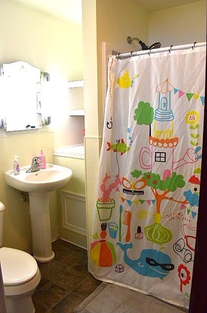 1207 4th Ave, Sterling, IL 61081 - bathroom with toilet, a shower with shower curtain, a sink, and stone finish floors