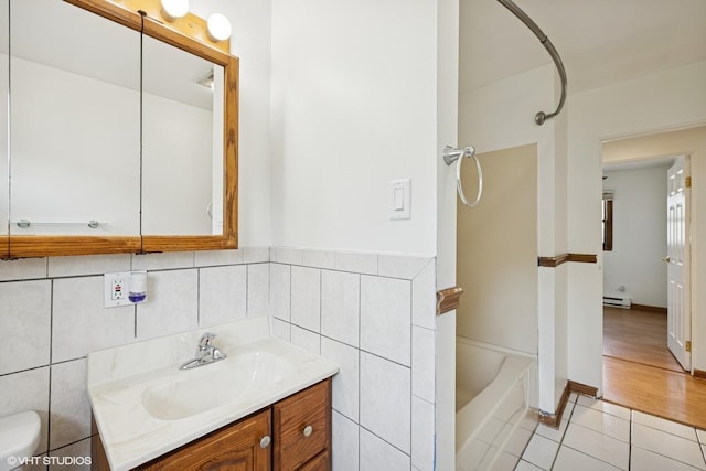 325 Larkdale Row, Wauconda, IL 60084 - bathroom with vanity, baseboard heating, tile patterned flooring, bathing tub / shower combination, and tile walls
