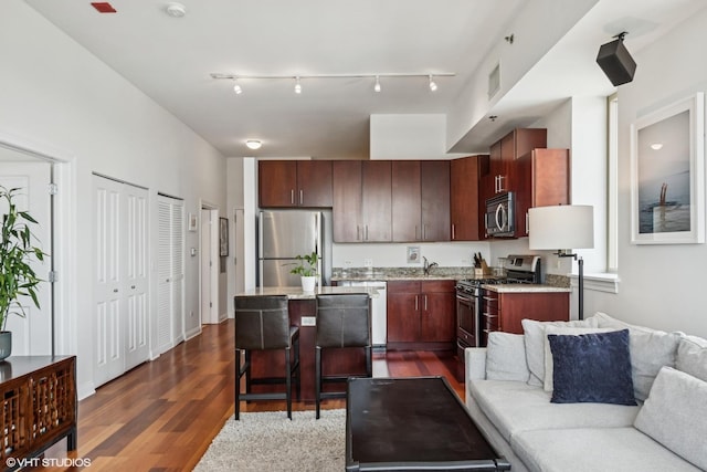 230 W Division St Unit 1208, Chicago, IL 60610 - kitchen featuring stainless steel appliances, open floor plan, dark wood-style floors, a kitchen island, and a kitchen breakfast bar