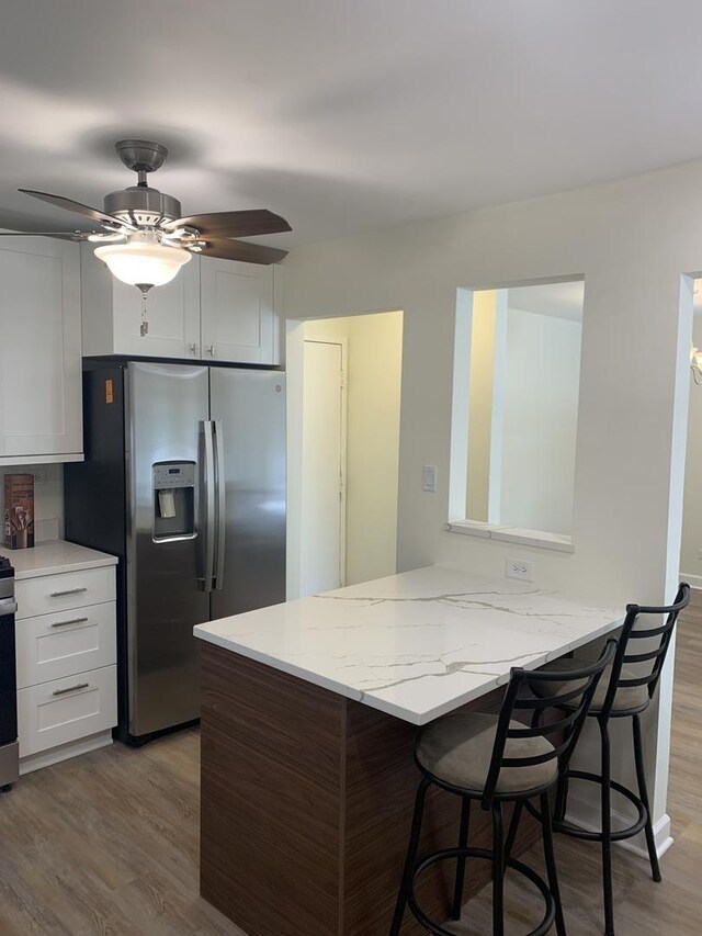 245 Park Ln Unit 208, Palatine, IL 60074 - kitchen with stainless steel fridge with ice dispenser, wood finished floors, a breakfast bar, light stone counters, and ceiling fan