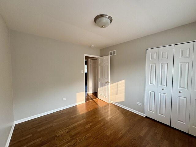 4230 Barry Ln, Oak Forest, IL 60452 - unfurnished bedroom with dark wood-style flooring, baseboards, and a closet