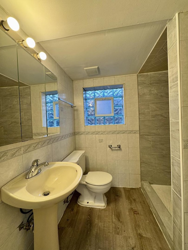 4230 Barry Ln, Oak Forest, IL 60452 - bathroom with tile walls, wood finished floors, toilet, a tile shower, and plenty of natural light
