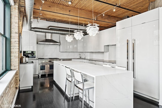 411 W Ontario St Unit 201-302, Chicago, IL 60654 - kitchen with modern cabinets, range with two ovens, wall chimney exhaust hood, white cabinetry, and a center island