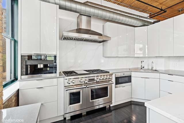 411 W Ontario St Unit 201-302, Chicago, IL 60654 - kitchen featuring stainless steel appliances, wall chimney exhaust hood, a sink, and modern cabinets
