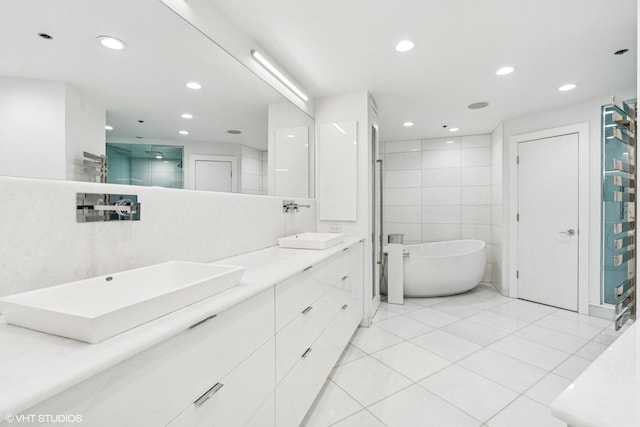 411 W Ontario St Unit 201-302, Chicago, IL 60654 - bathroom with double vanity, a soaking tub, recessed lighting, tile patterned flooring, and a stall shower