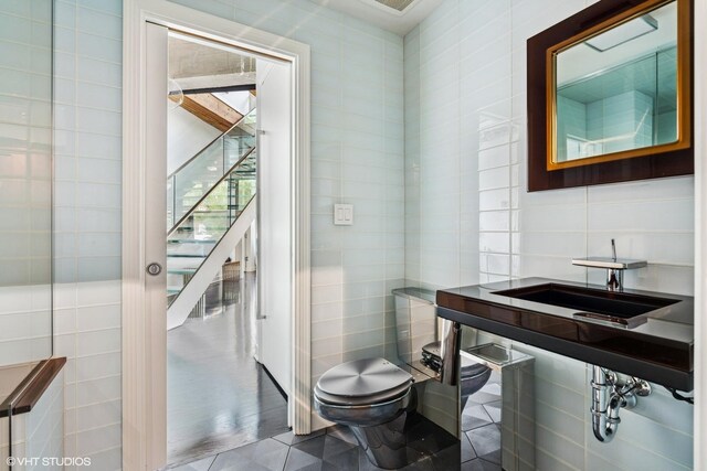 411 W Ontario St Unit 201-302, Chicago, IL 60654 - half bathroom featuring tile walls, toilet, a sink, and tile patterned flooring