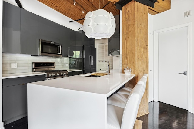 411 W Ontario St Unit 201-302, Chicago, IL 60654 - kitchen featuring appliances with stainless steel finishes, a sink, dark cabinetry, wood ceiling, and light countertops