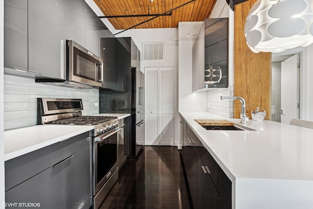 411 W Ontario St Unit 201-302, Chicago, IL 60654 - kitchen with appliances with stainless steel finishes, a sink, wooden ceiling, light countertops, and modern cabinets