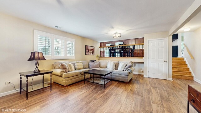 2443 Maple St, River Grove, IL 60171 - living area featuring light wood finished floors, baseboards, stairway, and a chandelier