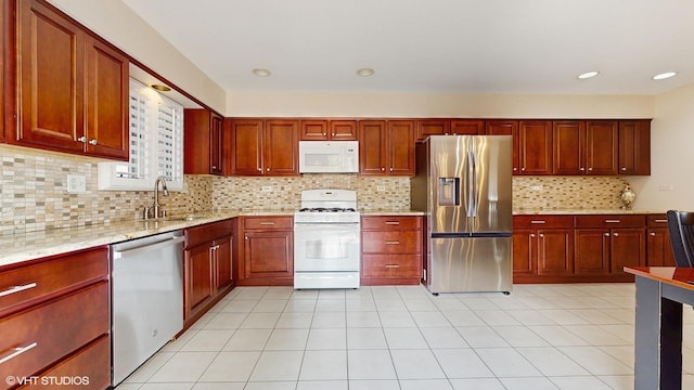 2443 Maple St, River Grove, IL 60171 - kitchen with stainless steel appliances, a sink, backsplash, light stone counters, and reddish brown cabinets