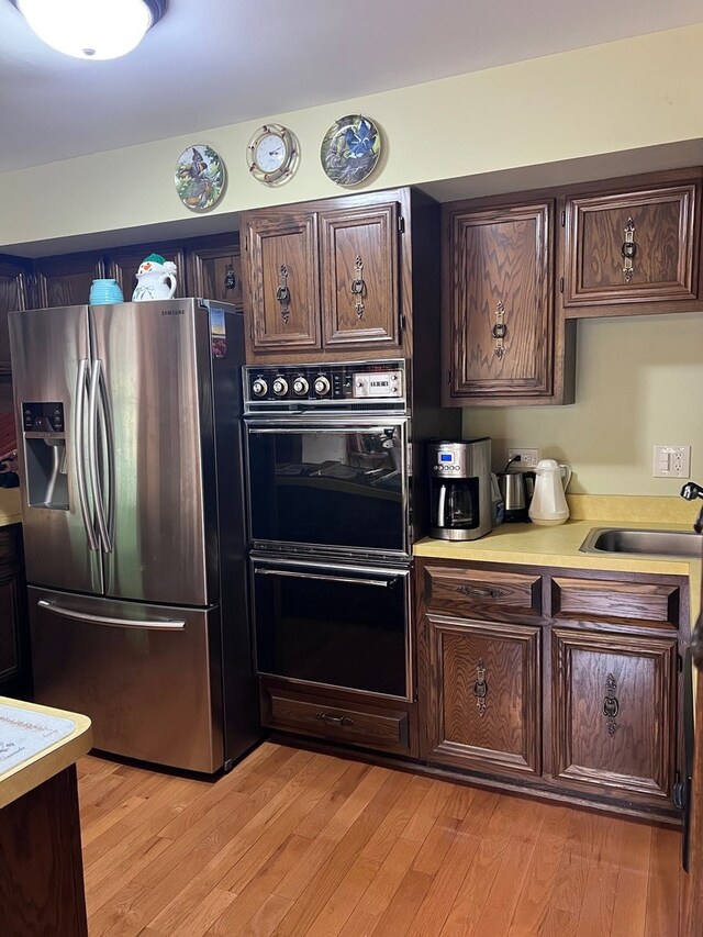 38W361 Binnie Rd, Dundee, IL 60118 - kitchen featuring stainless steel refrigerator with ice dispenser, a sink, light countertops, dark brown cabinetry, and light wood-type flooring