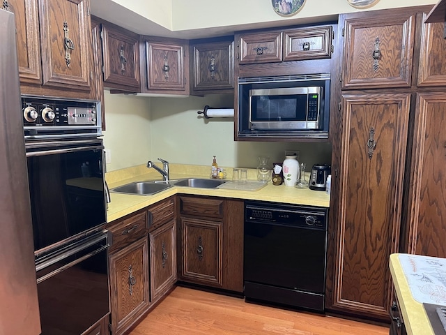 38W361 Binnie Rd, Dundee, IL 60118 - kitchen featuring black appliances, light countertops, a sink, light wood-type flooring, and dark brown cabinets