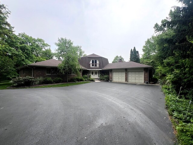 38W361 Binnie Rd, Dundee, IL 60118 - view of front of house with a garage, asphalt driveway, and brick siding