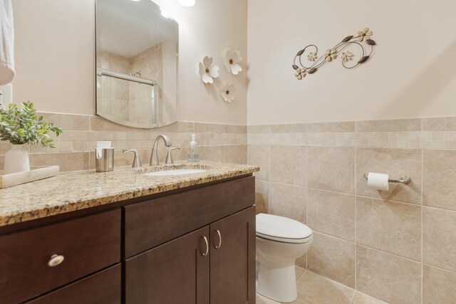 298 Fern Dr, Elk Grove Village, IL 60007 - bathroom featuring toilet, vanity, tiled shower, and tile walls