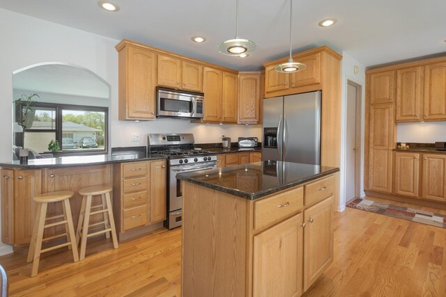 298 Fern Dr, Elk Grove Village, IL 60007 - kitchen featuring appliances with stainless steel finishes, arched walkways, light wood-type flooring, recessed lighting, and a kitchen island
