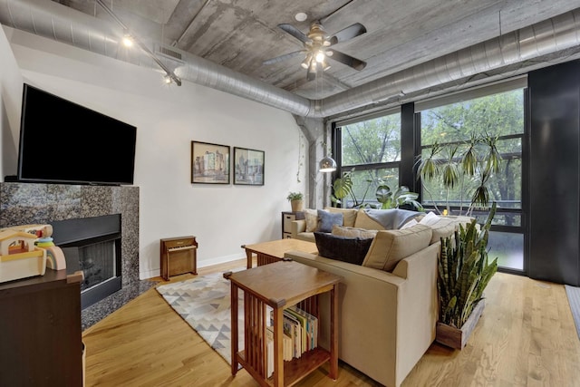 1110 W 15th St Unit 228, Chicago, IL 60608 - living room featuring light wood finished floors, a fireplace, ceiling fan, baseboards, and rail lighting