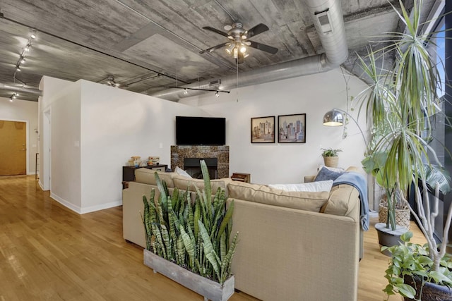 1110 W 15th St Unit 228, Chicago, IL 60608 - living area featuring track lighting, a stone fireplace, light wood-type flooring, ceiling fan, and baseboards