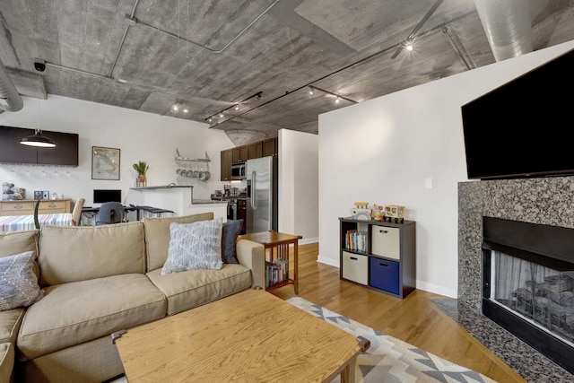 1110 W 15th St Unit 228, Chicago, IL 60608 - living area with track lighting, light wood finished floors, a fireplace with flush hearth, and baseboards