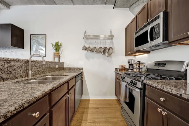 1110 W 15th St Unit 228, Chicago, IL 60608 - kitchen featuring stainless steel appliances, a sink, stone counters, light wood finished floors, and baseboards