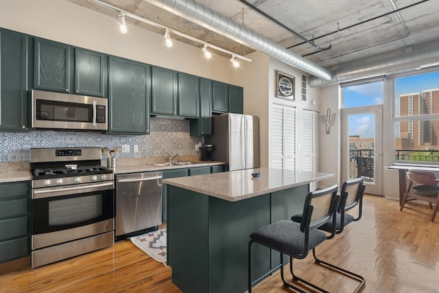 6 S Laflin St Unit 518, Chicago, IL 60607 - kitchen with stainless steel appliances, rail lighting, backsplash, and light wood-style floors