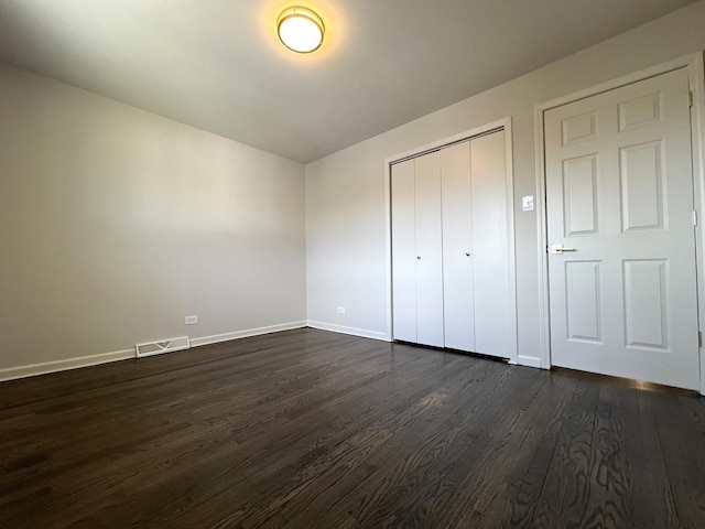 14425 Sanderson Ave, Dolton, IL 60419 - unfurnished bedroom with dark wood-type flooring, baseboards, and a closet
