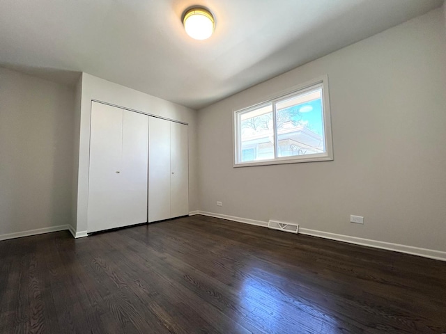 14425 Sanderson Ave, Dolton, IL 60419 - unfurnished bedroom with dark wood finished floors, baseboards, and a closet