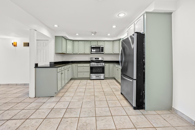 5110 W Lake Shore Dr, Wonder Lake, IL 60097 - kitchen with stainless steel appliances, light tile patterned floors, dark countertops, recessed lighting, and green cabinetry