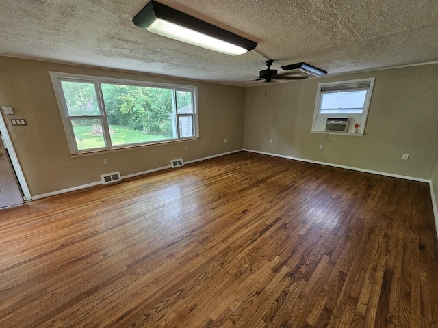 1311 N Neil St, Champaign, IL 61820 - empty room with a textured ceiling, wood finished floors, healthy amount of natural light, cooling unit, and ceiling fan
