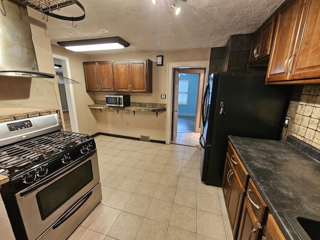 1311 N Neil St, Champaign, IL 61820 - kitchen featuring appliances with stainless steel finishes, backsplash, light tile patterned floors, baseboards, and a textured ceiling