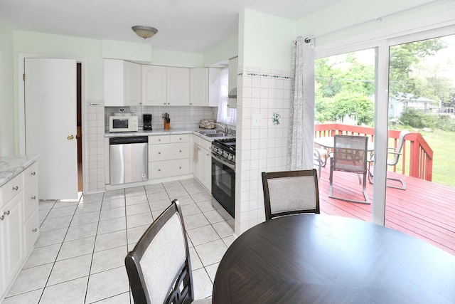 1N485 Neltnor Blvd, West Chicago, IL 60185 - kitchen featuring appliances with stainless steel finishes, light countertops, white cabinetry, tasteful backsplash, and light tile patterned flooring