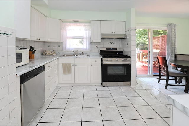 1N485 Neltnor Blvd, West Chicago, IL 60185 - kitchen featuring appliances with stainless steel finishes, under cabinet range hood, light tile patterned floors, white cabinets, and backsplash