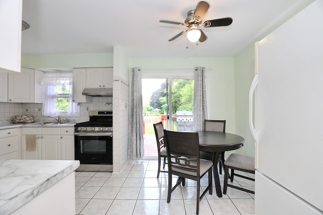 1N485 Neltnor Blvd, West Chicago, IL 60185 - kitchen featuring stainless steel range with gas stovetop, freestanding refrigerator, under cabinet range hood, and light tile patterned floors
