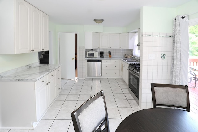 1N485 Neltnor Blvd, West Chicago, IL 60185 - kitchen featuring white microwave, stainless steel dishwasher, black gas stove, and white cabinetry