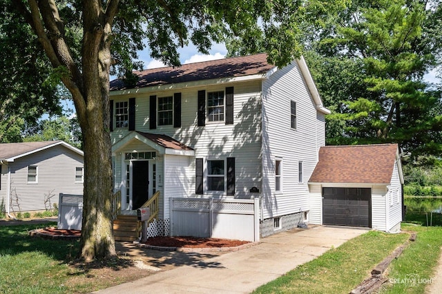 455 N River St, Montgomery, IL 60538 - colonial house featuring concrete driveway, an outbuilding, roof with shingles, and an attached garage