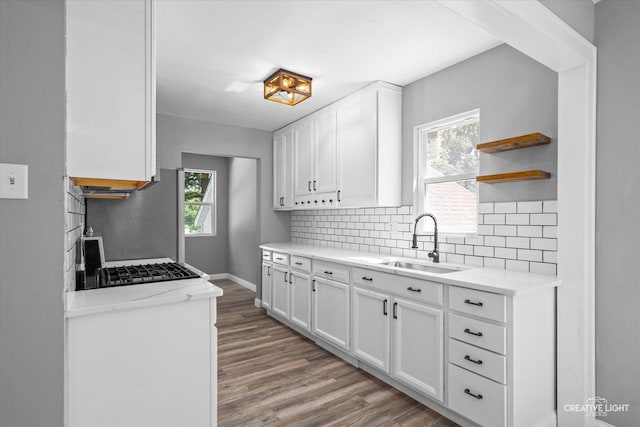 455 N River St, Montgomery, IL 60538 - kitchen with open shelves, tasteful backsplash, light wood-style floors, and white cabinetry