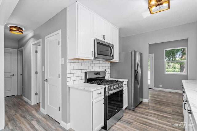 455 N River St, Montgomery, IL 60538 - kitchen with appliances with stainless steel finishes, light wood-type flooring, light stone countertops, and white cabinetry