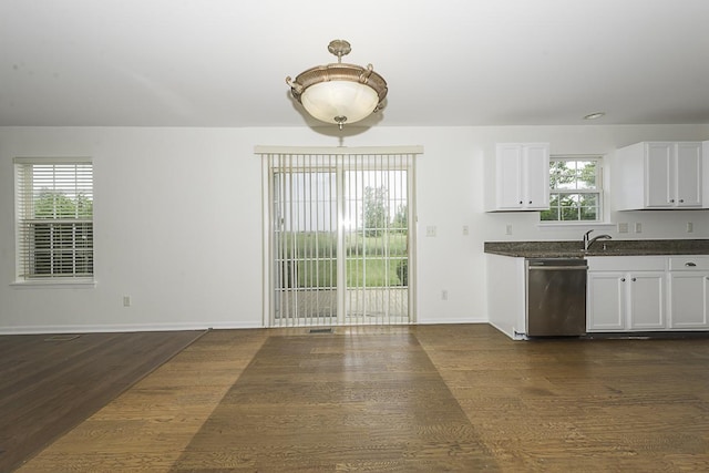 149 W Prairiefield Ave, Cortland, IL 60112 - kitchen featuring stainless steel dishwasher, dark countertops, dark wood-style flooring, baseboards, and white cabinetry