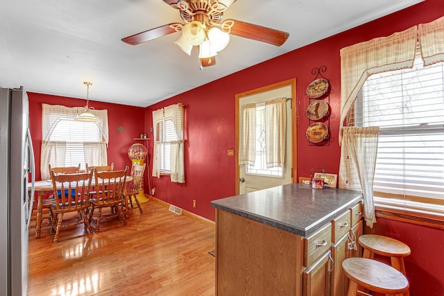 2105 Sanford Ave, New Lenox, IL 60451 - kitchen with freestanding refrigerator, dark countertops, a ceiling fan, light wood finished floors, and brown cabinetry