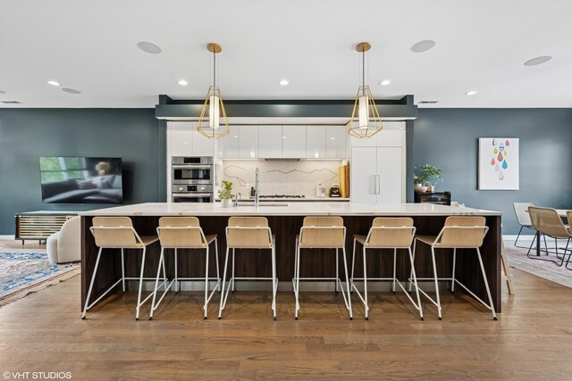 1233 N Paulina St Unit 3N, Chicago, IL 60622 - kitchen with a sink, modern cabinets, double oven, white cabinets, and wood finished floors