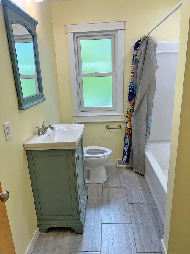 241 N Somonauk Rd, Cortland, IL 60112 - full bath featuring toilet, vanity, wood finished floors, shower / bath combination with curtain, and baseboards