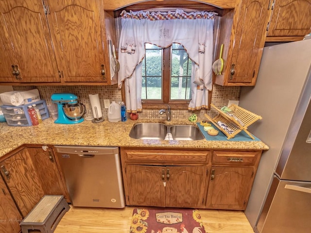 601 Fairlane Dr, Joliet, IL 60435 - kitchen featuring stainless steel appliances, tasteful backsplash, brown cabinetry, light wood-style flooring, and light stone countertops