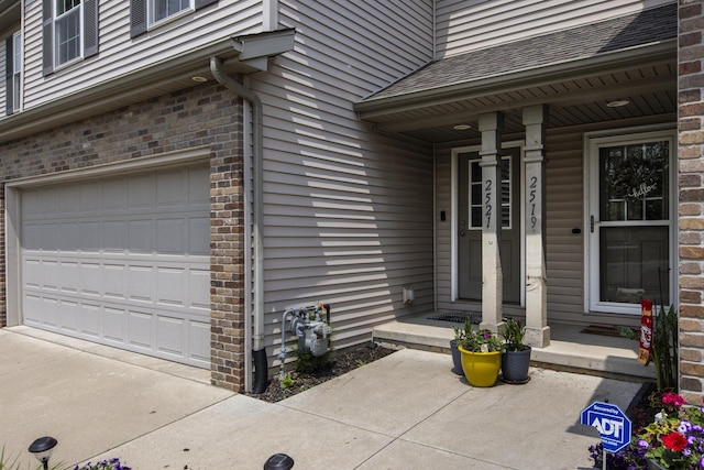 2521 Fox Trot Trl, Bloomington, IL 61705 - doorway to property with an attached garage, brick siding, and a porch