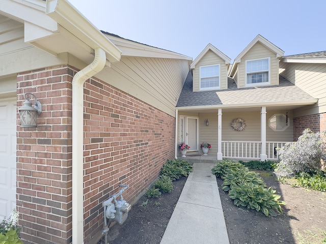 503 Shagbark Dr Unit 503, Elgin, IL 60123 - doorway to property featuring a porch, roof with shingles, and brick siding