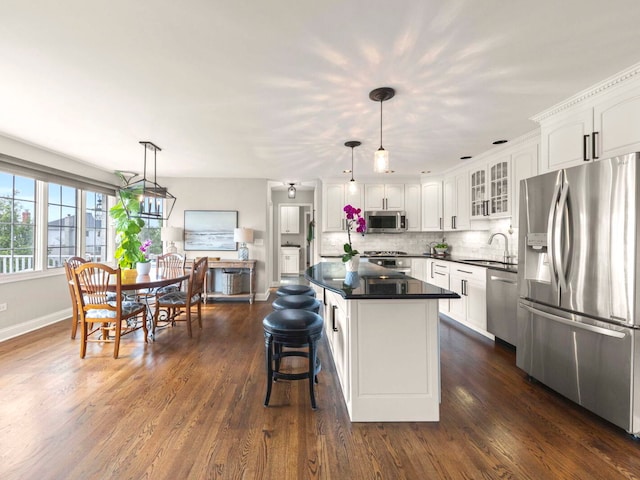 18210 W Winds Ln, Orland Park, IL 60467 - kitchen with appliances with stainless steel finishes, dark countertops, white cabinets, glass insert cabinets, and a kitchen island