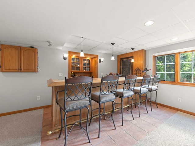 18210 W Winds Ln, Orland Park, IL 60467 - kitchen featuring a breakfast bar area, pendant lighting, baseboards, a peninsula, and a drop ceiling